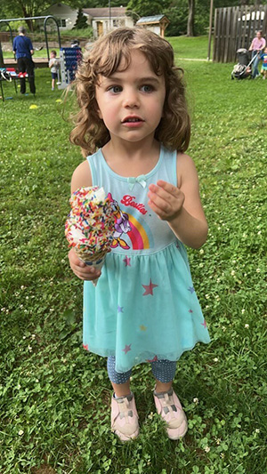 Little girl holding an ice cream cone with sprinkles